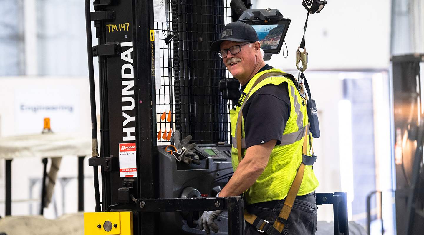 HODGE employee harnessed to forklift for safety